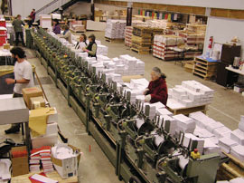Foto aus der Druckerei von Dharma Publishing mit Druckmaschinen, Lagerung und freiwilligen Helfern
	