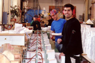 Volunteer working with the press to print the sacred text